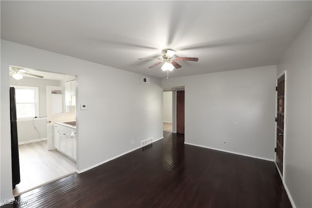 spare room with ceiling fan and dark hardwood / wood-style flooring