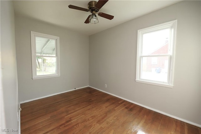 spare room with dark hardwood / wood-style flooring and ceiling fan