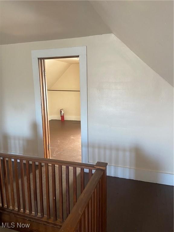 stairs featuring baseboards and lofted ceiling