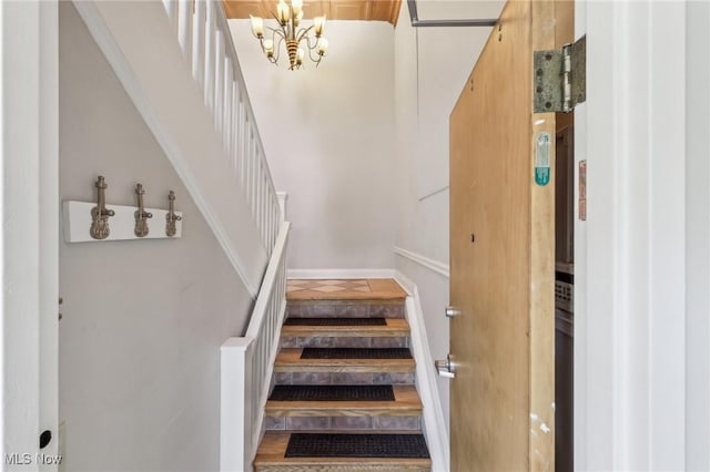 staircase featuring a notable chandelier