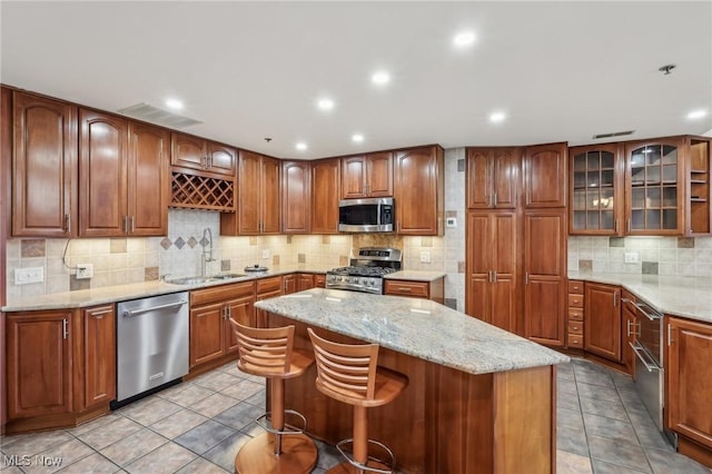 kitchen with a center island, appliances with stainless steel finishes, sink, and a kitchen breakfast bar