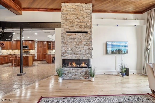 living room with wood ceiling, a fireplace, and light hardwood / wood-style floors