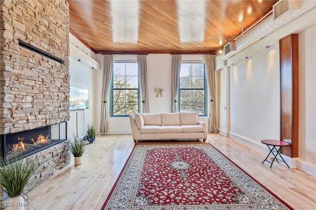 sunroom featuring a fireplace, a wealth of natural light, and wooden ceiling