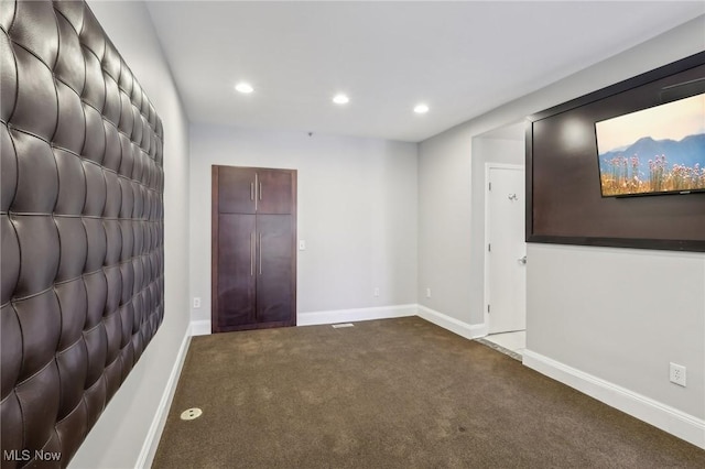 unfurnished room with dark colored carpet