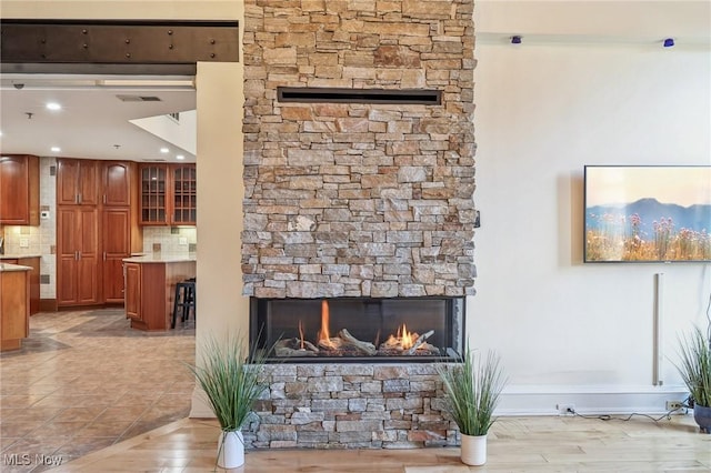 tiled living room with a stone fireplace