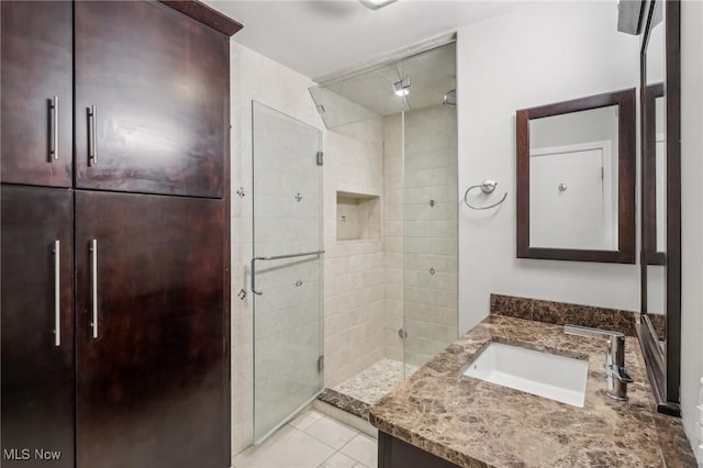 bathroom with vanity, a shower with shower door, and tile patterned floors