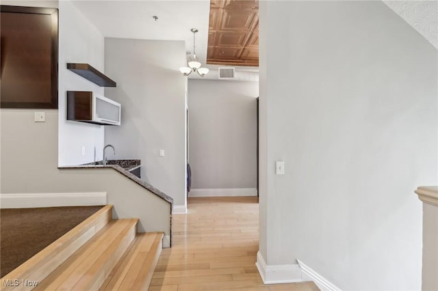 staircase with an inviting chandelier and hardwood / wood-style flooring