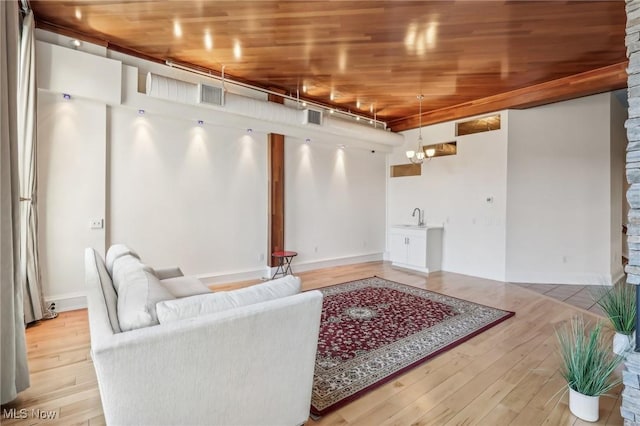 living room with sink, wooden ceiling, a chandelier, and light wood-type flooring