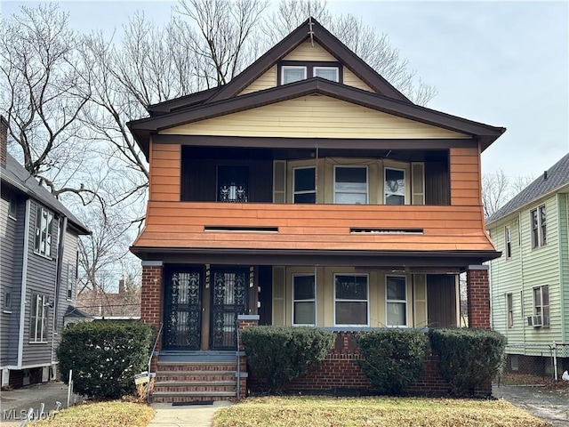 1245 E 137th St, East Cleveland, OH 44112 - view of front facade with brick siding, a balcony, covered porch, and cooling unit