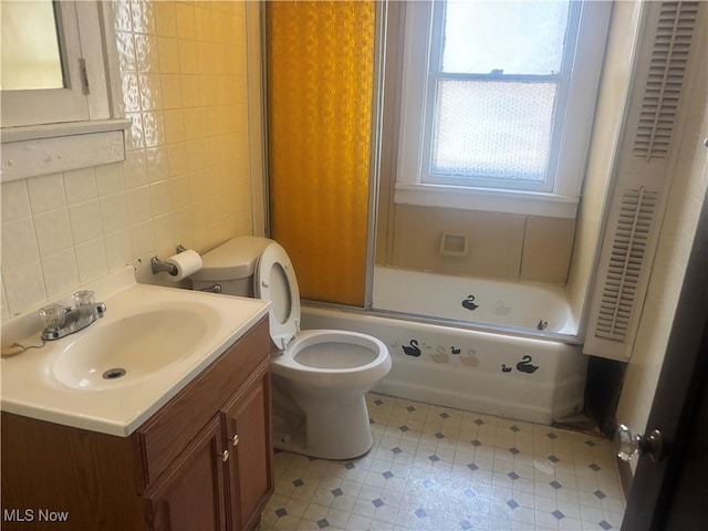 1245 E 137th St, East Cleveland, OH 44112 - full bathroom with tile walls, tasteful backsplash, vanity, toilet, and shower / bath combination with glass door