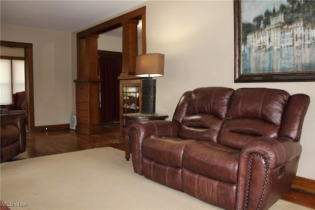 living room featuring dark hardwood / wood-style flooring and ornate columns