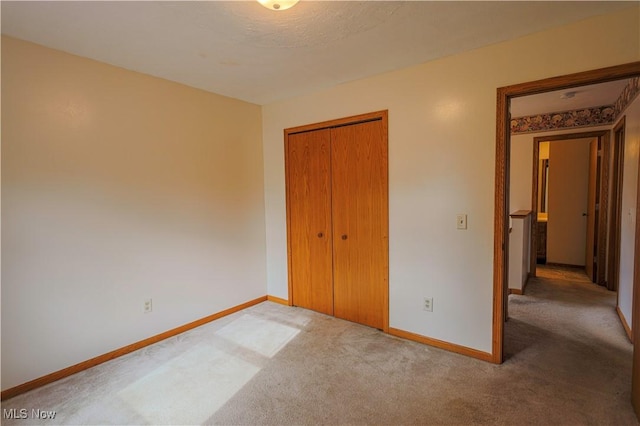 unfurnished bedroom featuring carpet floors and a closet