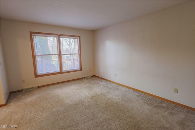 spare room featuring light colored carpet