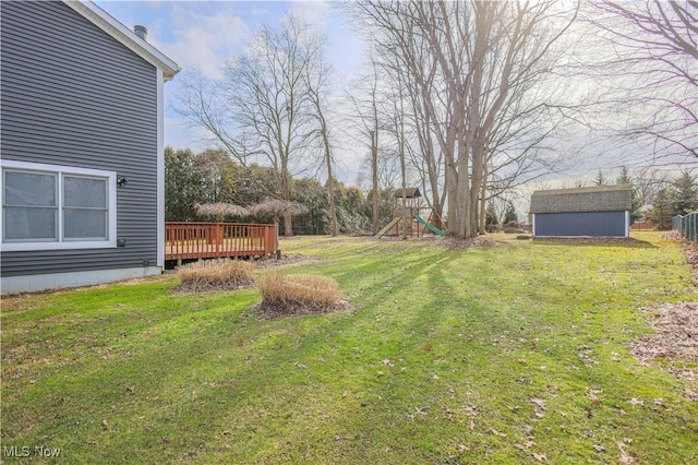 view of yard with a shed, a wooden deck, and a playground