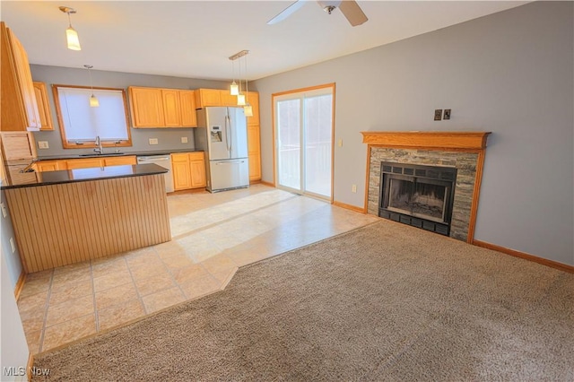 kitchen featuring sink, decorative light fixtures, light carpet, light brown cabinets, and stainless steel appliances