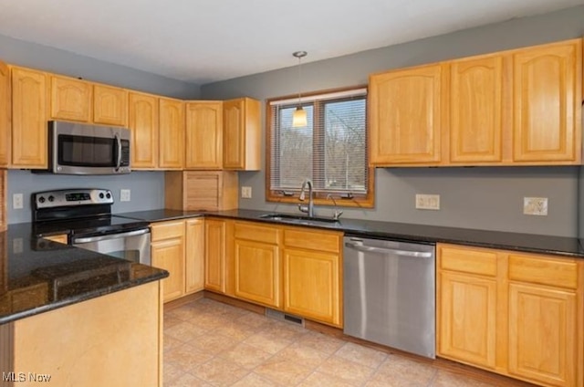 kitchen with pendant lighting, sink, dark stone countertops, stainless steel appliances, and light brown cabinets