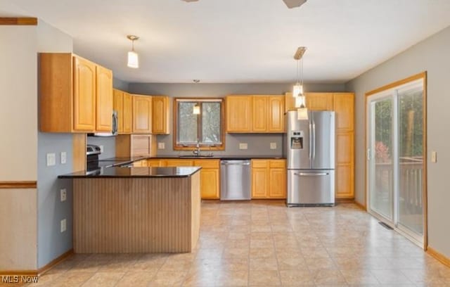 kitchen with hanging light fixtures, sink, kitchen peninsula, and appliances with stainless steel finishes