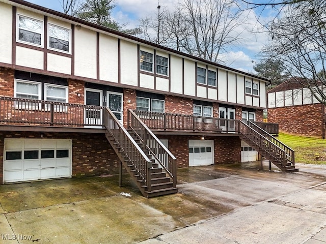 back of property featuring a garage and a deck