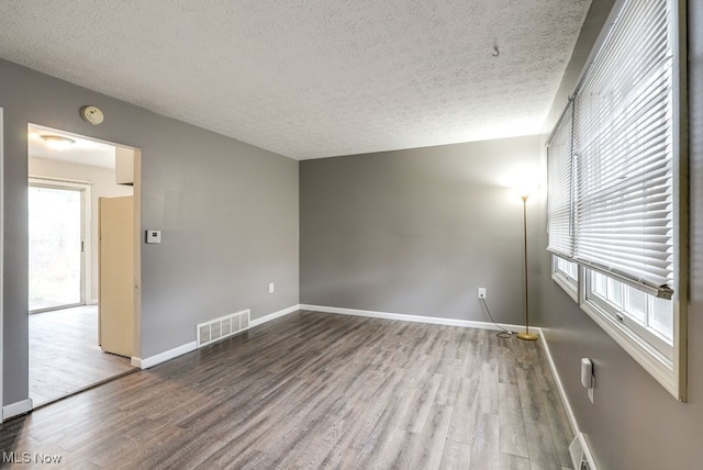 spare room with hardwood / wood-style floors and a textured ceiling