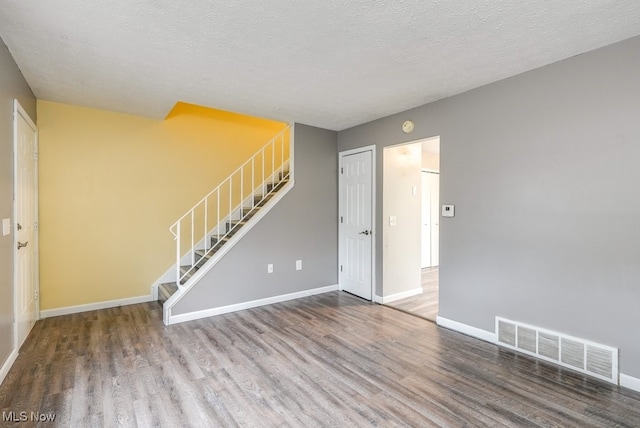 spare room featuring hardwood / wood-style flooring and a textured ceiling