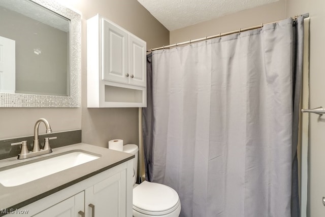 bathroom featuring vanity, toilet, and a textured ceiling