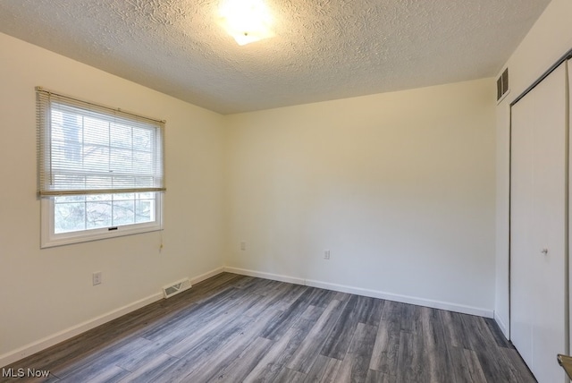 interior space featuring a closet, dark hardwood / wood-style floors, and a textured ceiling