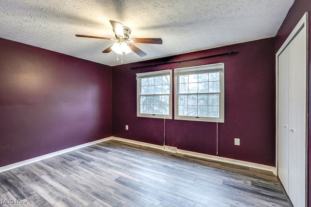 spare room featuring ceiling fan, hardwood / wood-style flooring, and a textured ceiling