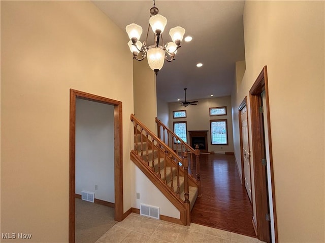 interior space with ceiling fan with notable chandelier and a high ceiling