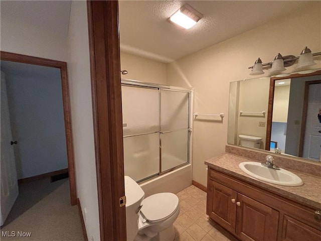 full bathroom with vanity, bath / shower combo with glass door, and toilet