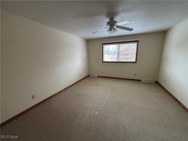 carpeted spare room featuring ceiling fan and a textured ceiling