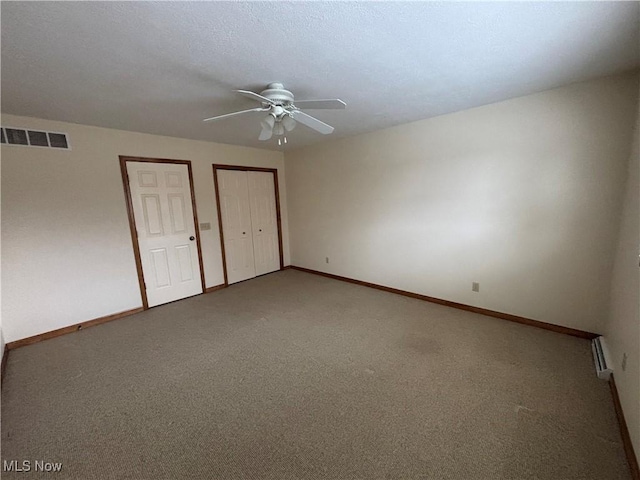 unfurnished bedroom with multiple closets, ceiling fan, and carpet floors