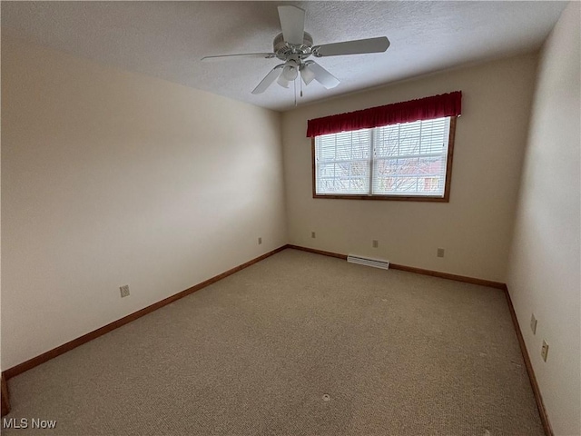 spare room with ceiling fan, a textured ceiling, and carpet flooring