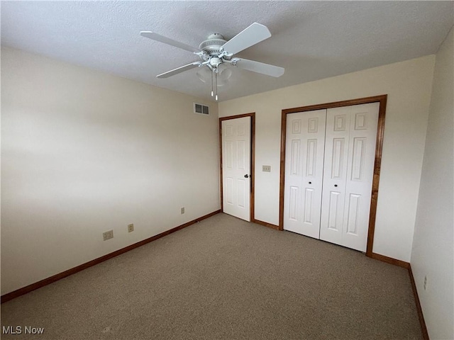 unfurnished bedroom featuring a textured ceiling, carpet floors, a closet, and ceiling fan