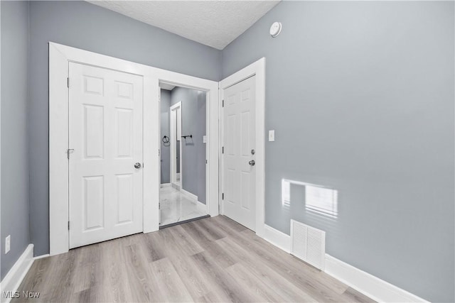 interior space featuring light hardwood / wood-style flooring and a textured ceiling