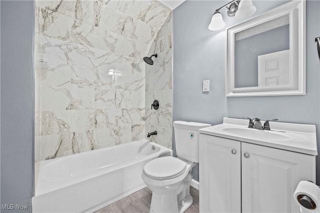 full bathroom featuring tiled shower / bath combo, wood-type flooring, vanity, and toilet