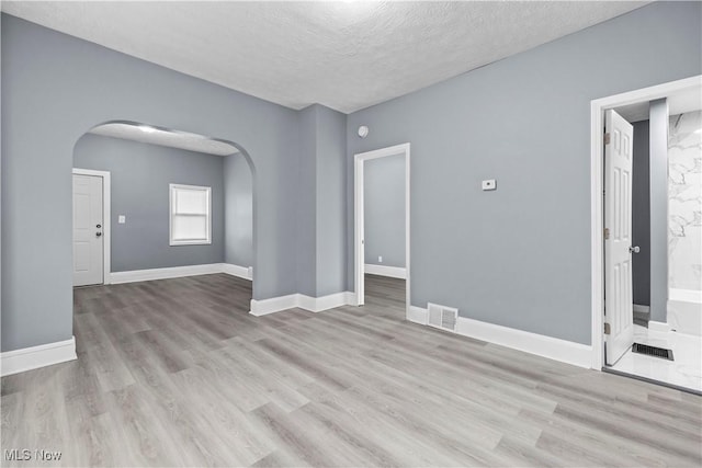 empty room featuring light hardwood / wood-style floors and a textured ceiling