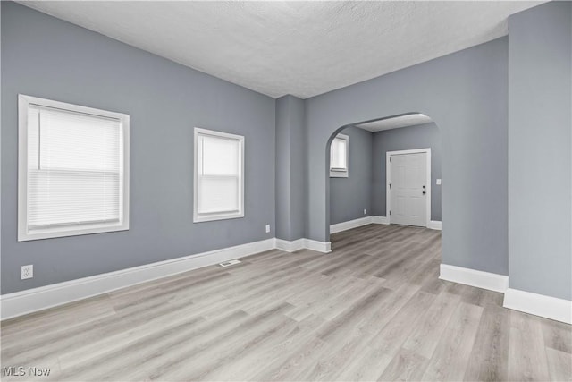 empty room featuring light hardwood / wood-style flooring and a textured ceiling