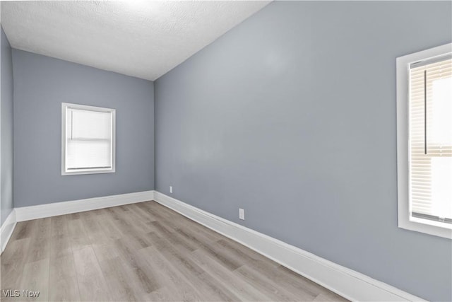 empty room featuring light hardwood / wood-style floors and a textured ceiling