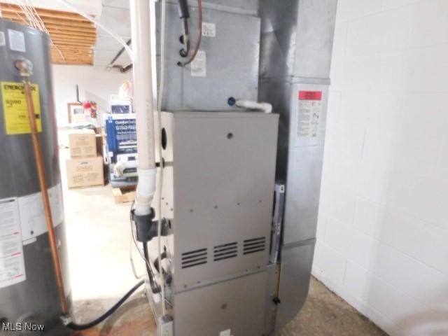 utility room featuring heating unit and gas water heater