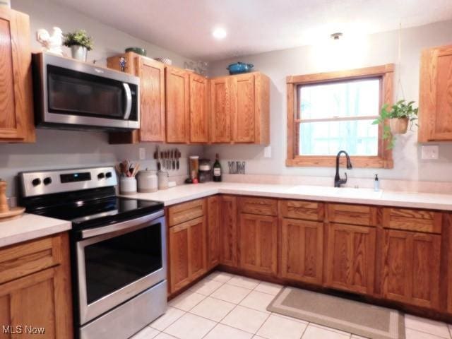 kitchen featuring appliances with stainless steel finishes, sink, and light tile patterned floors