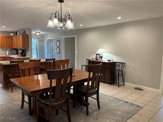 dining room with a textured ceiling and light tile patterned floors