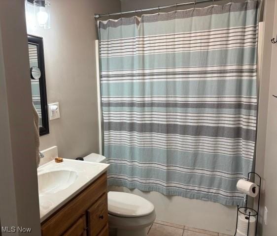 full bathroom with shower / bath combination with curtain, vanity, tile patterned floors, and toilet