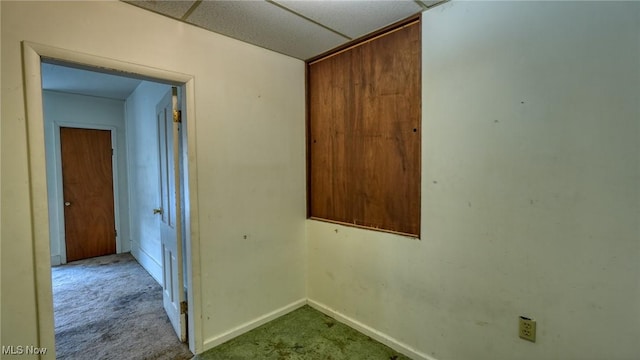 carpeted empty room with a paneled ceiling