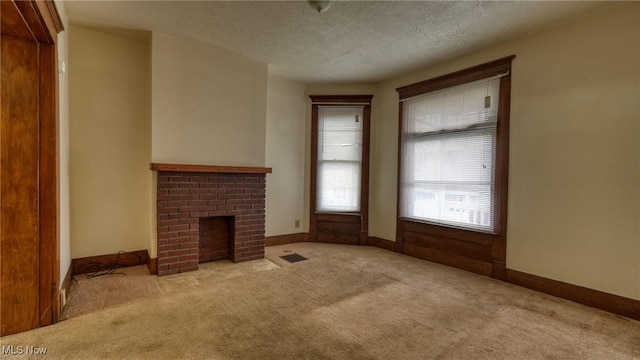 unfurnished living room featuring light carpet, a textured ceiling, and a fireplace