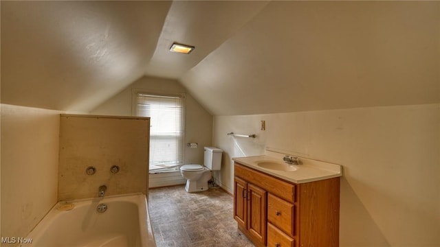 bathroom featuring vanity, lofted ceiling, a bathtub, and toilet