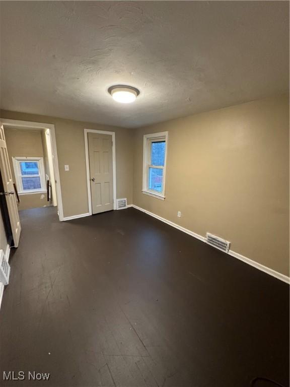 empty room featuring wood-type flooring and a textured ceiling