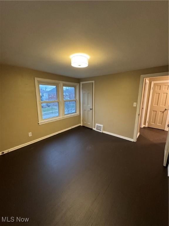 empty room with dark wood-type flooring