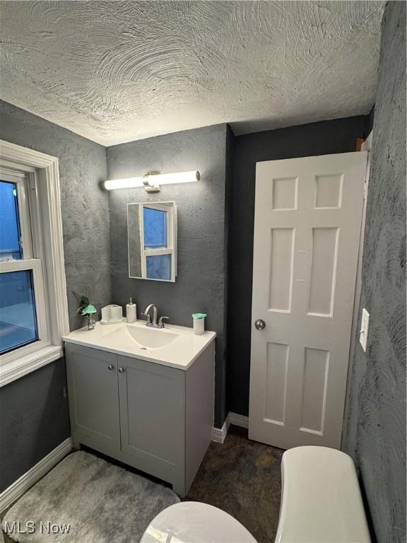 bathroom featuring vanity, toilet, and a textured ceiling