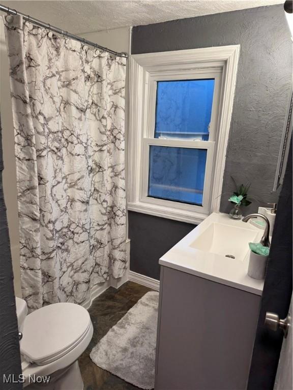 bathroom featuring vanity, toilet, and a textured ceiling