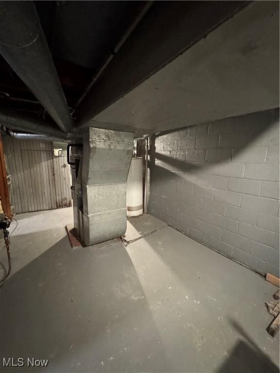 basement featuring water heater and heating unit